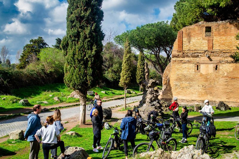 Cyclists on the ancient Appian Way near Rome aqueducts